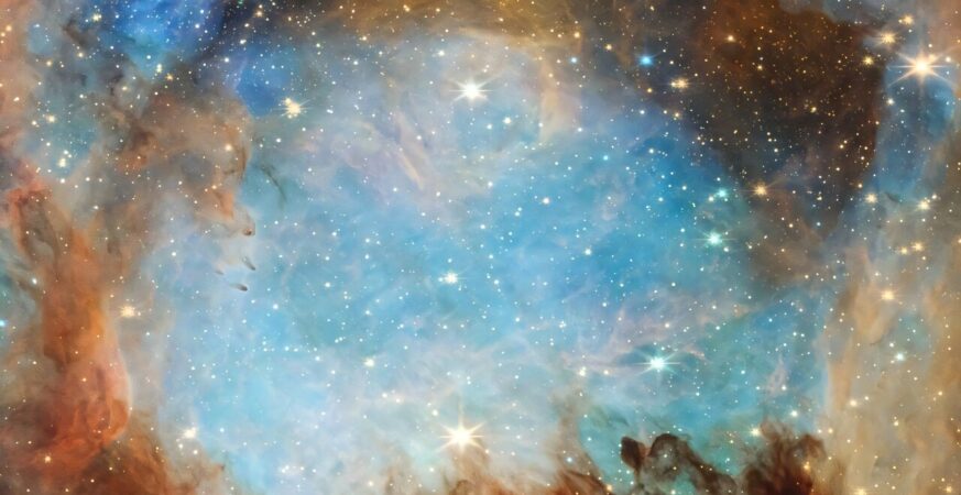 This is a zoomed-in portion of the JWST's Cat's Paw image. It shows a cavity surrounded by filaments and clumps of gas and dust. The cavity has been hollowed out by a hot young star which lights its surroundings up in blue. Credit: NASA, ESA, CSA, STScI